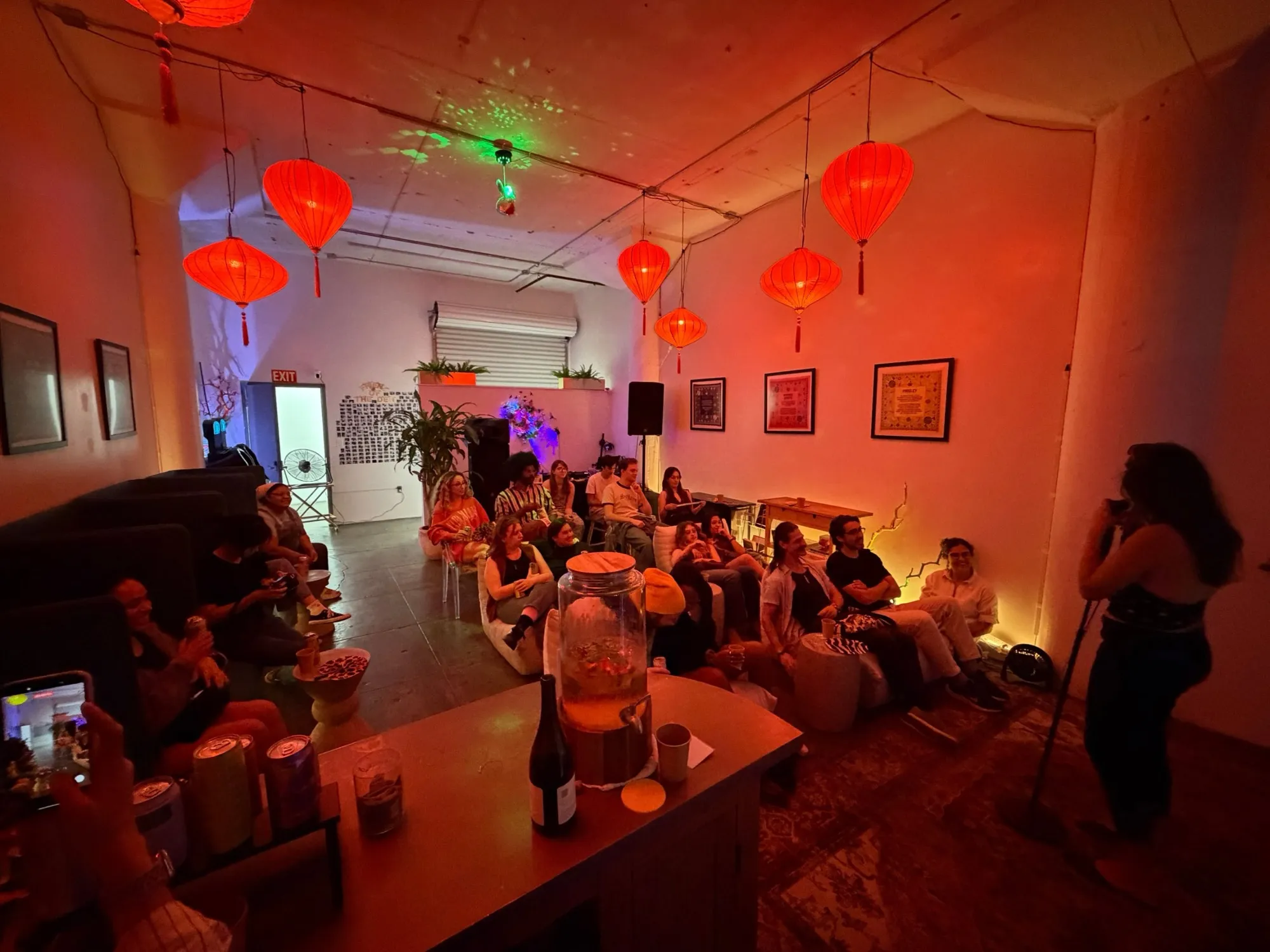 A comedy night at the Den, guests on lounge seats under red lanterns