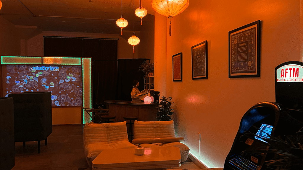 Interior of Bu Tea Den speakeasy tea lounge in DTLA with dim lights, red lanterns, and drifting paisley projections